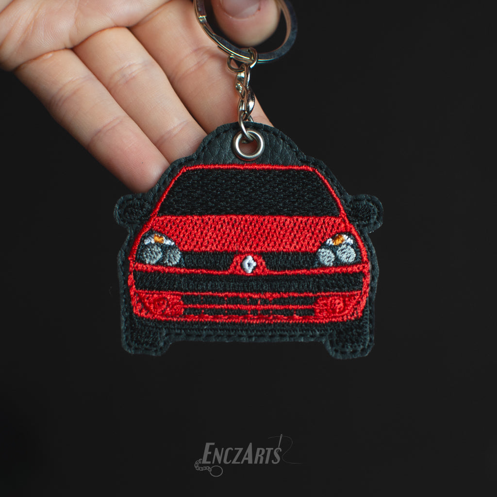 Haftowany brelok EnczArts przedstawiający czerwone Renault Thalia rękodzieło inspirowane klasykami motoryzacji.