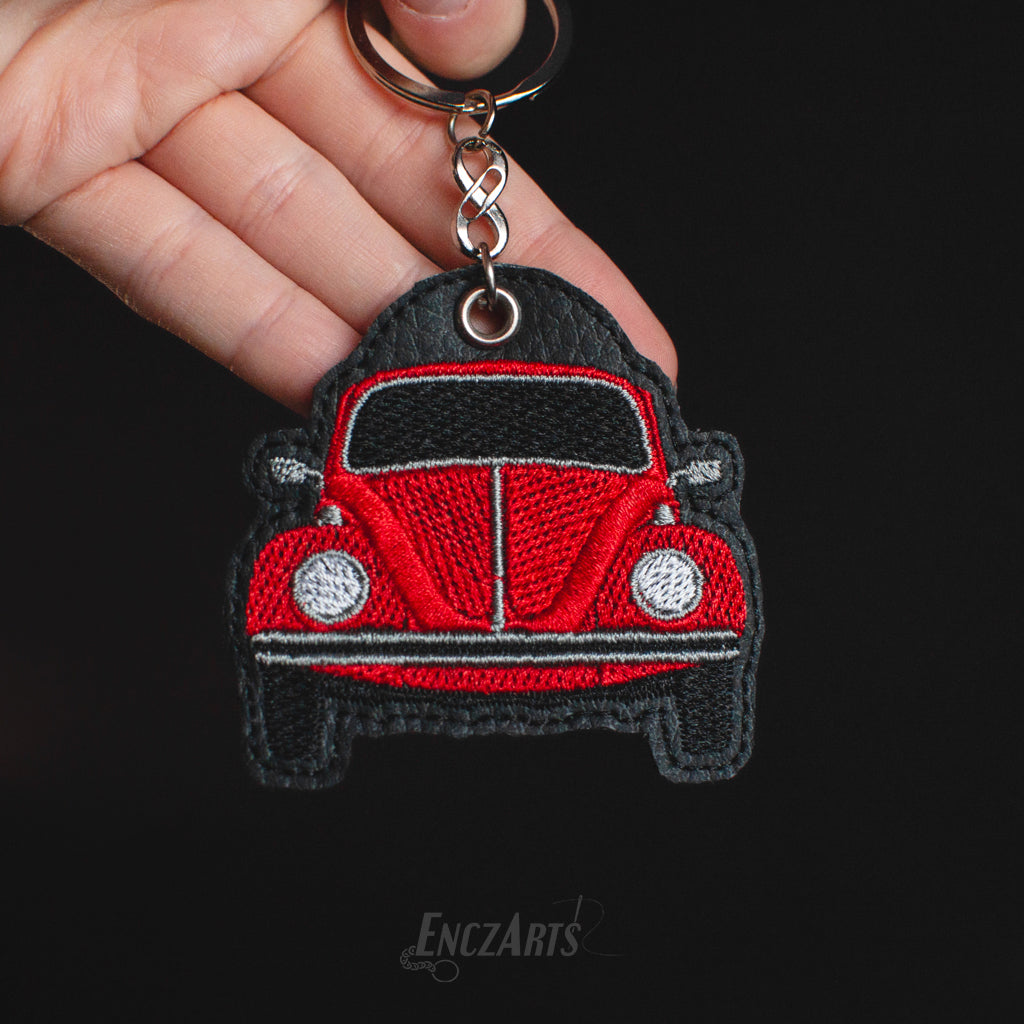 Haftowany brelok EnczArts przedstawiający czerwonego Garbusa rękodzieło inspirowane klasykami motoryzacji.