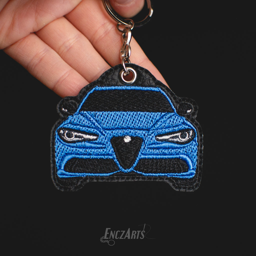 Haftowany brelok samochodowy EnczArts przedstawiający Alfa Romeo Giulia niebieska wyjątkowe rękodzieło dla miłośników motoryzacji 