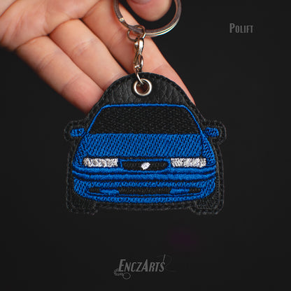 Haftowany brelok samochodowy EnczArts model Opel Calibra polift w kolorze granatowym.