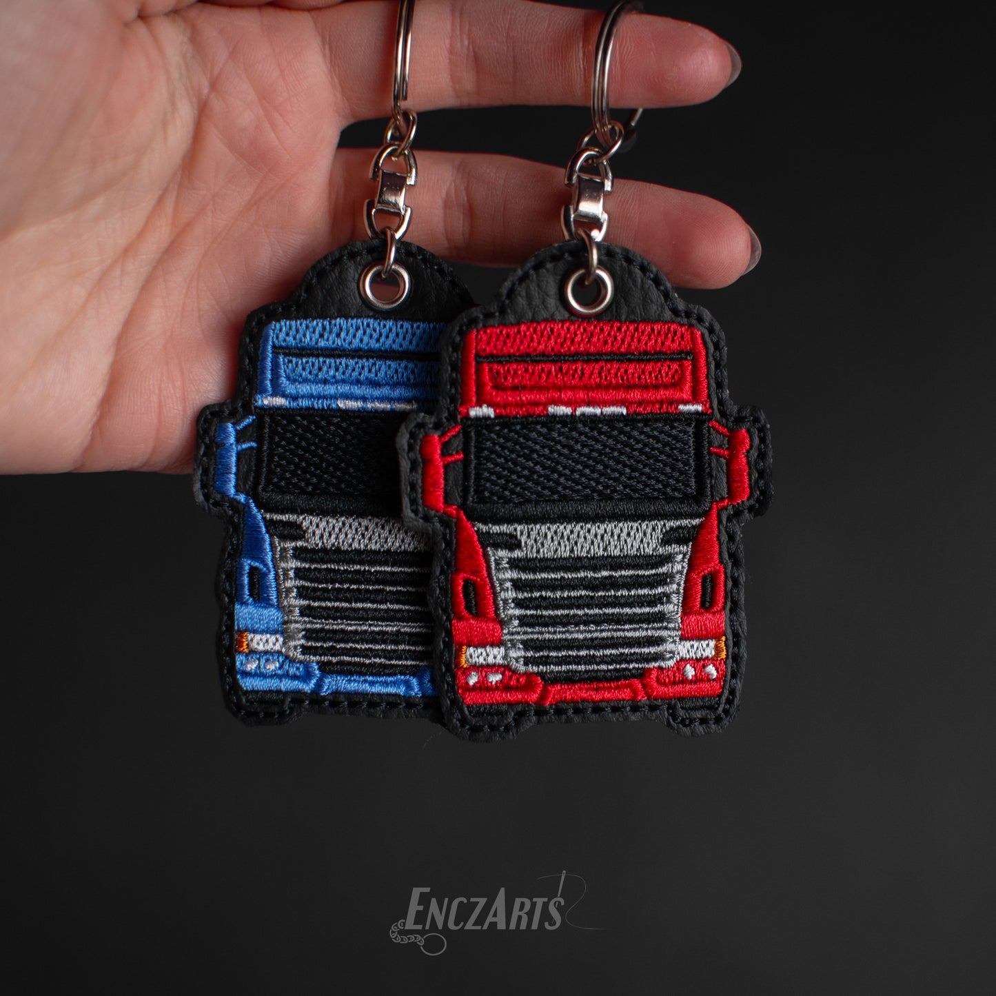 Haftowane breloki ciężarówki EnczArts model SCANIA R R440 w kolorze czerwonym i niebieskim.
