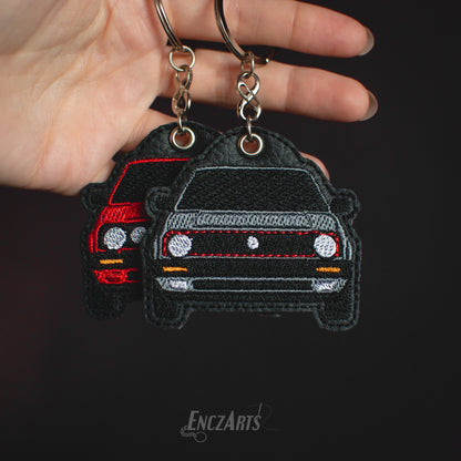 Haftowane breloi EnczArts przedstawiający dwa Volkswageny Golf II inspirowane klasykami motoryzacji.