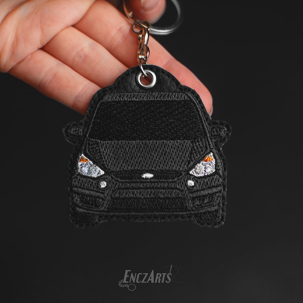 Haftowany brelok EnczArts przedstawiający czarnego Forda S-MAX rękodzieło inspirowane klasykami motoryzacji.